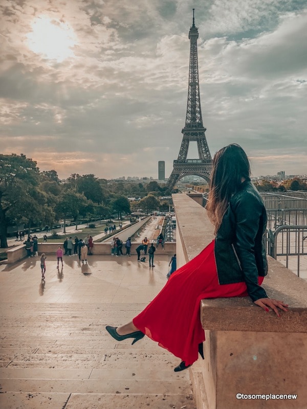女孩在埃菲尔铁塔在一个完美的4天巴黎行程-体验最好的观光与事情在巴黎4天，吃什么，住在哪里和其他旅行提示