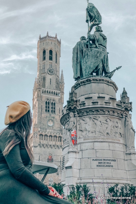 市场广场上的雕像。在布鲁日的一天行程中，准备好被姜饼屋、中世纪市场广场、浪漫运河之旅、比利时华夫饼和啤酒之旅迷住吧。