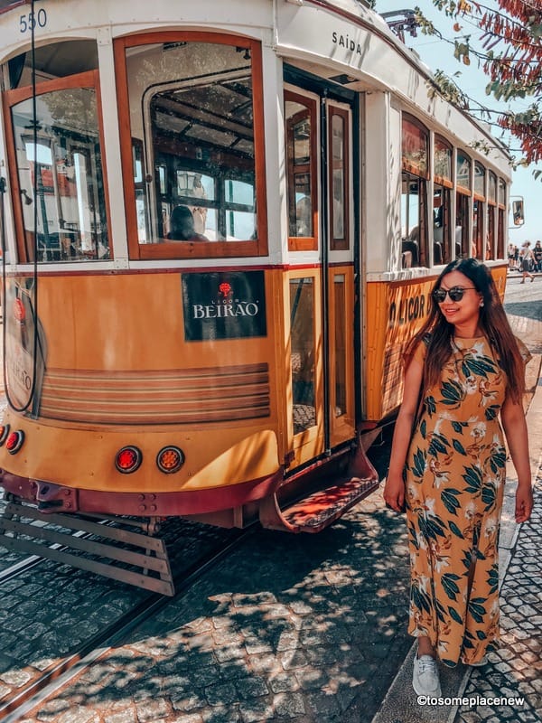 女孩与里斯本有轨电车合影。里斯本是欧洲最美丽的城市之一