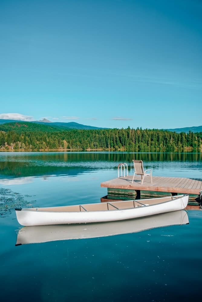 秋日清晨的荷兰湖，清水，加拿大不列颠哥伦比亚省。在平静的水面上划独木舟，湖面上有山的倒影