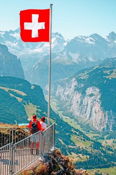 Mannlichen山顶上的瑞士国旗(少女峰地区，伯尔尼，瑞士)了解计划去瑞士旅行的小贴士