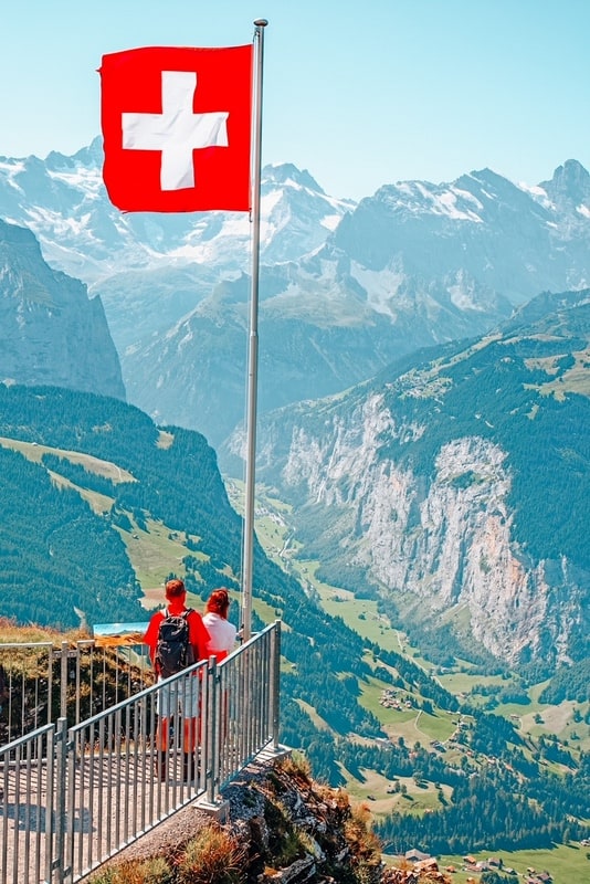 Mannlichen山顶上的瑞士国旗(少女峰地区，伯尔尼，瑞士)了解计划去瑞士旅行的小贴士