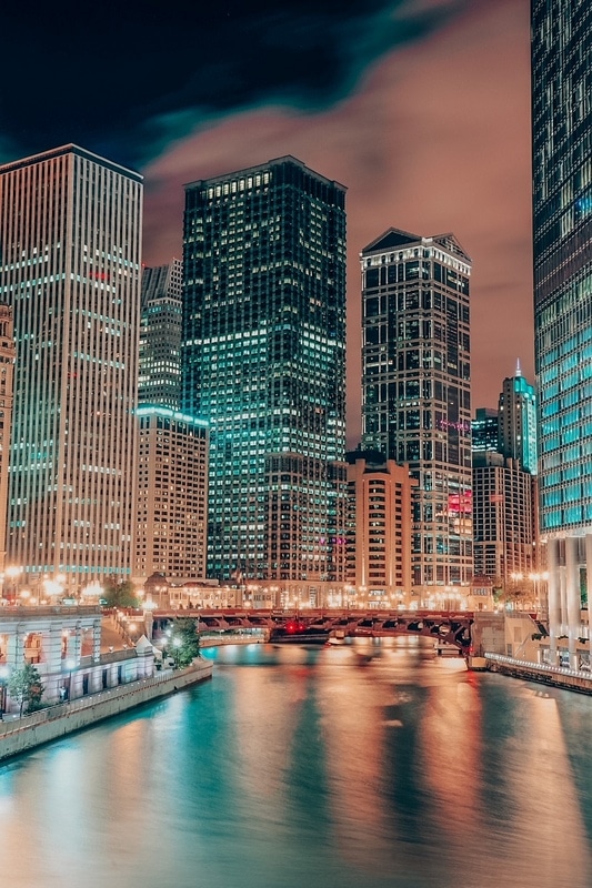 芝加哥河漫步，城市摩天大楼在夜晚被灯光和水反射照亮。