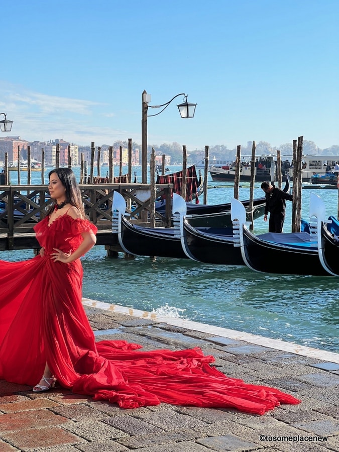 在威尼斯海滨穿红裙子的女孩